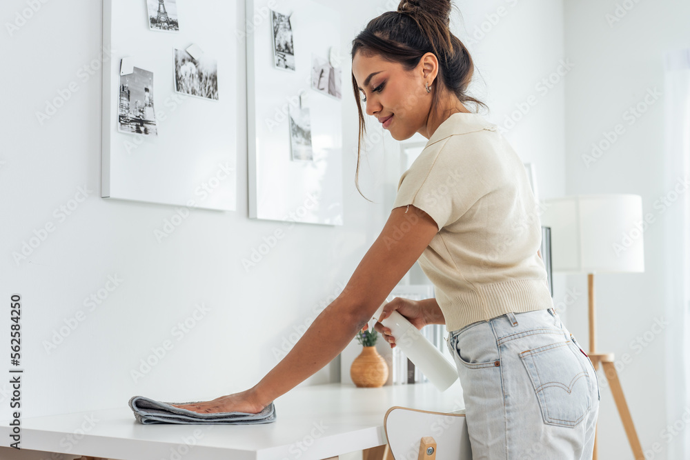 Caucasian beautiful young woman worker cleanning living room at home. 