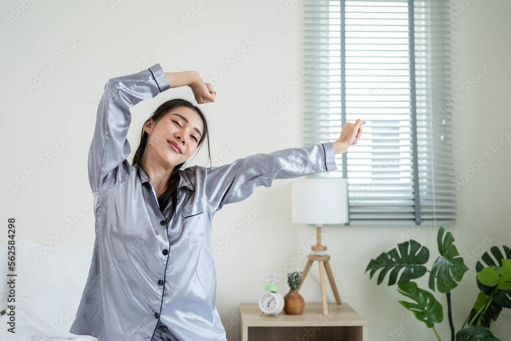 Asian beautiful girl in pajamas wake up in the morning with happiness. 