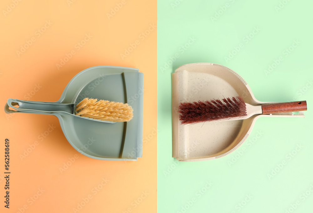 Dustpans and brushes on color background