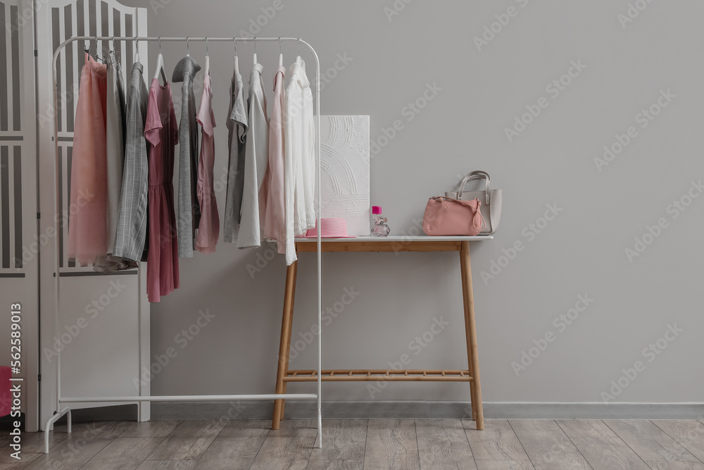 Rack with stylish female clothes in interior of room