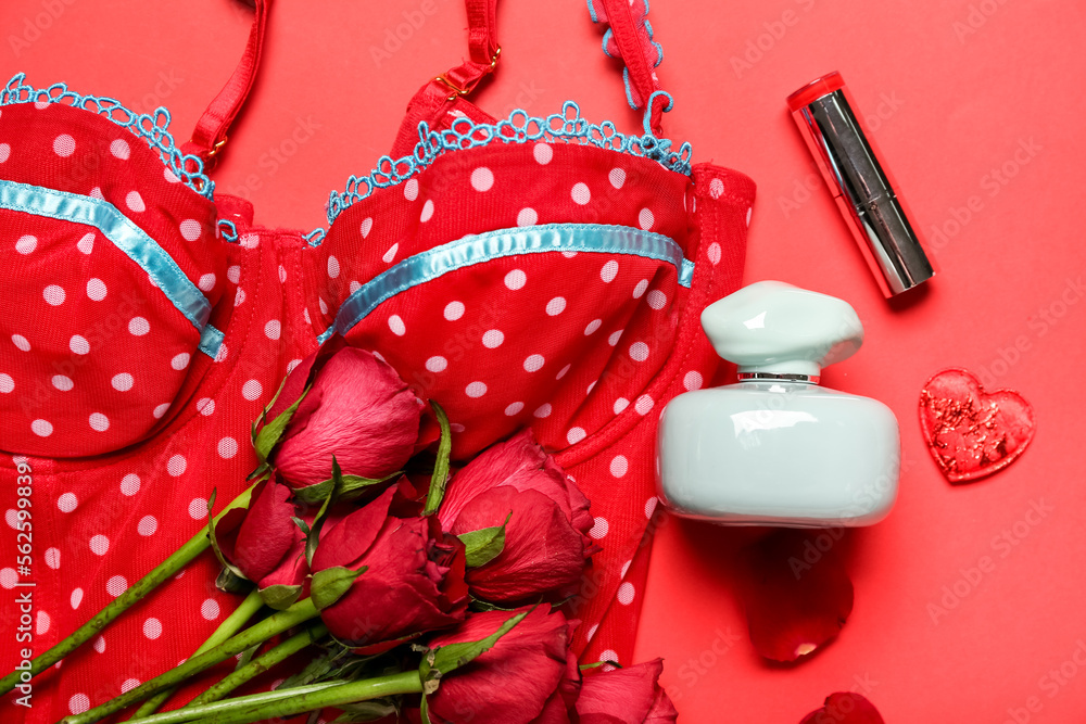 Perfume with lipstick, female underwear and roses for Valentines day on red background