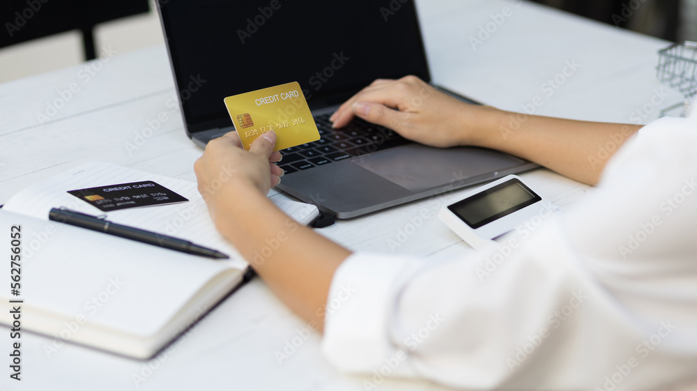 Woman holding credit card and using laptop. Online payment and online  shopping concept.