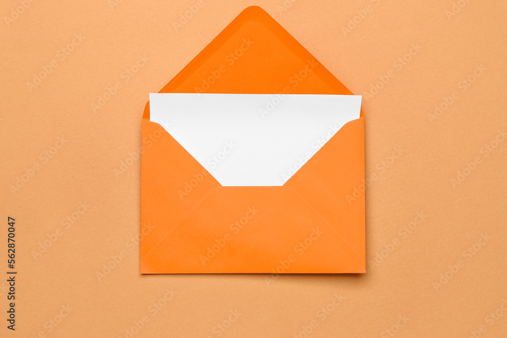 Orange paper envelope with card on color background