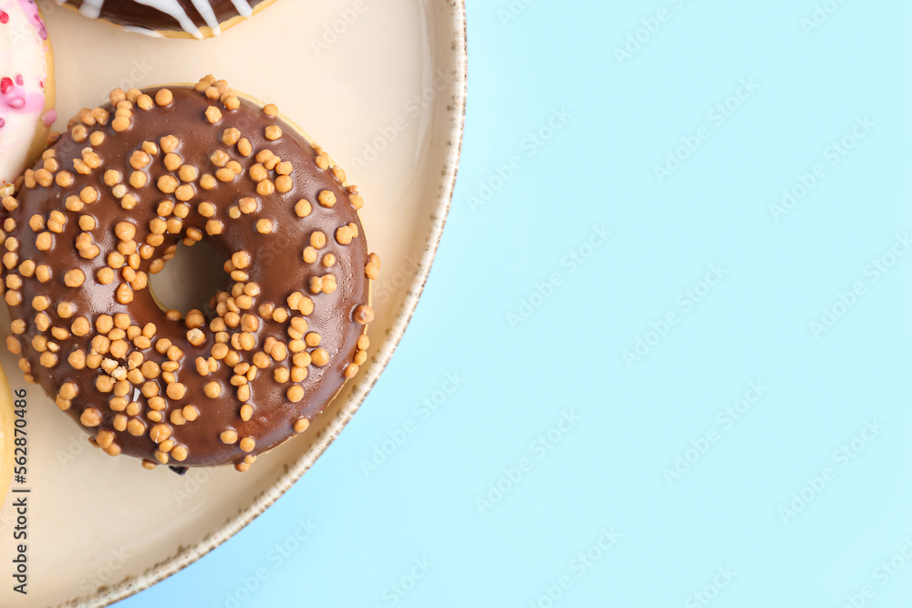 Plate with sweet chocolate donut on color background, closeup