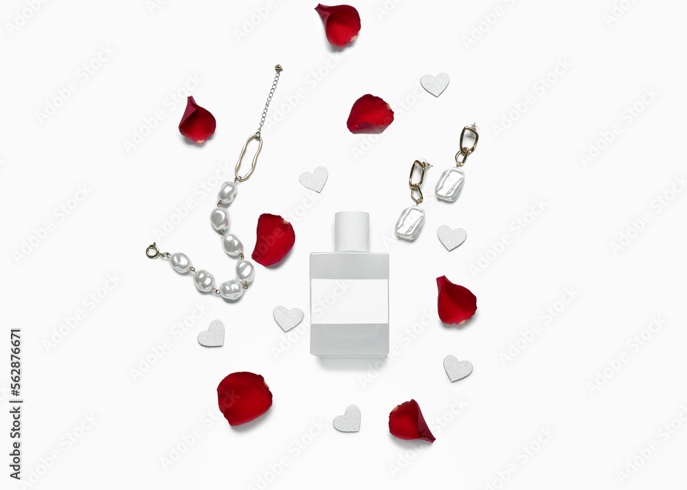 Perfume with jewelry, rose petals and hearts for Valentines day on white background