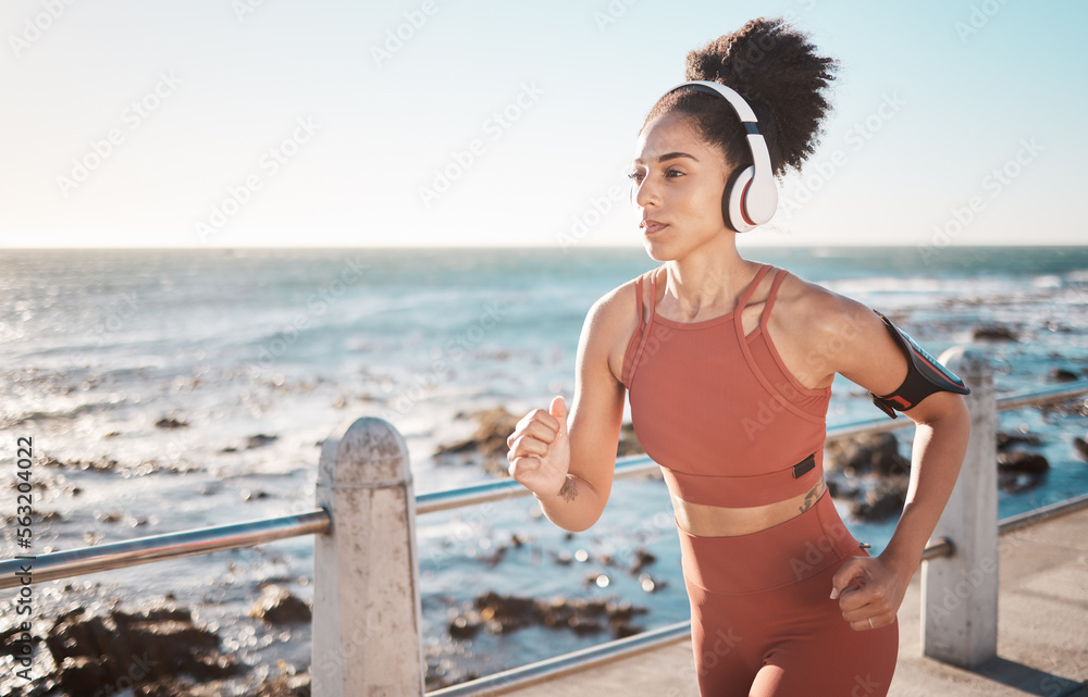 黑人女性，戴着耳机在开普敦海岬海滩健身跑步锻炼