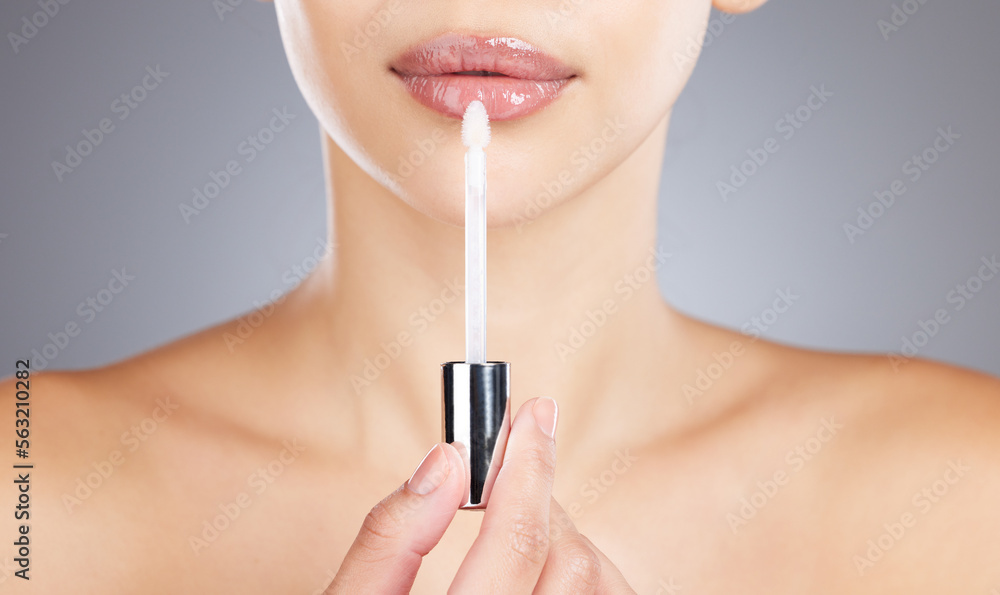 Woman, lips and lip gloss application for beauty, makeup shine and skincare wellness in grey backgro