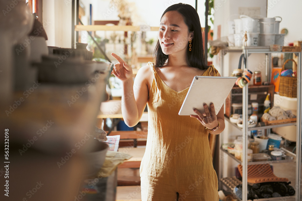 艺术工作室库存检查，一位企业家的女性和平板电脑数据正在检查商店信息。很高兴，s