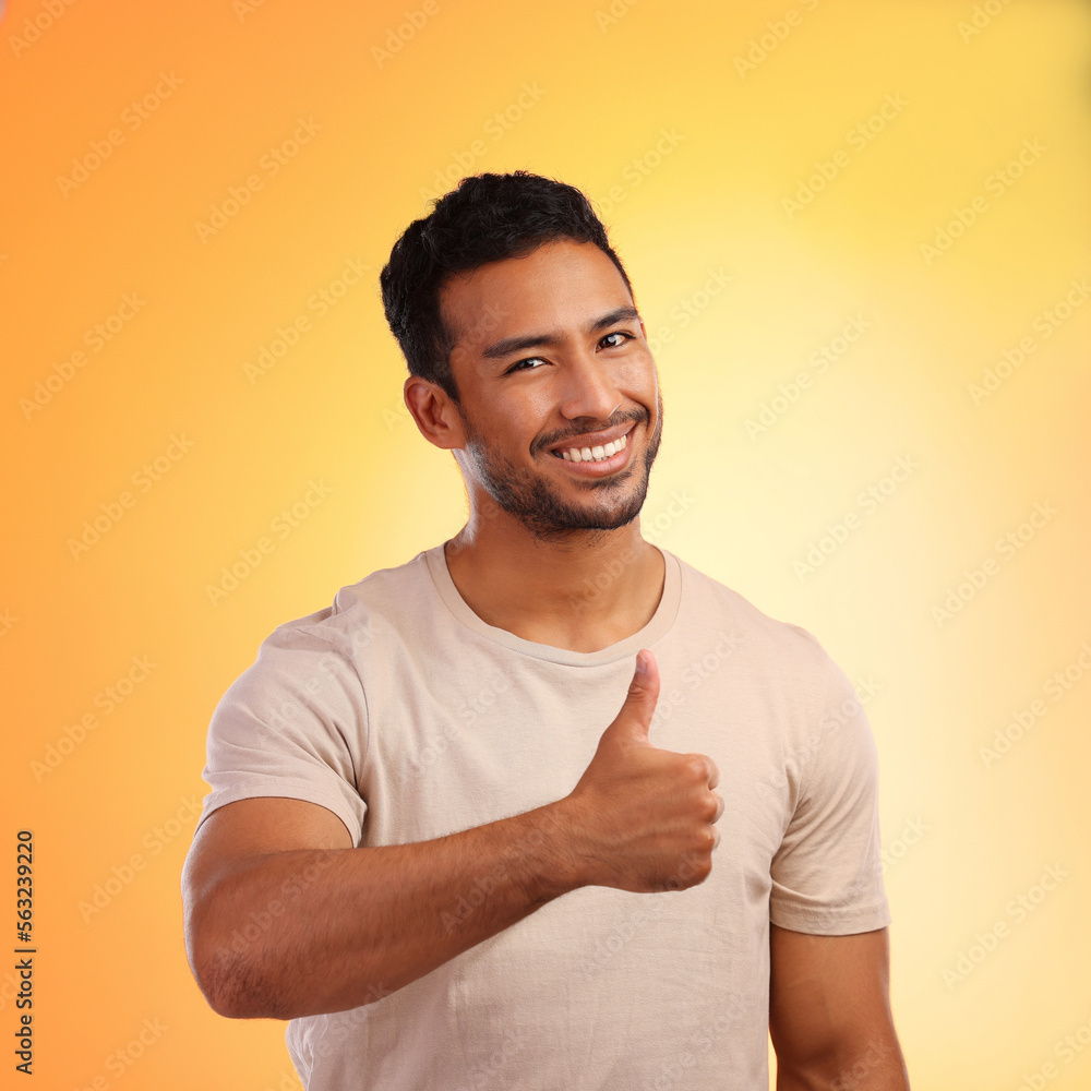 Hands, thumbs up and portrait of man in studio isolated on a yellow background. Face, fashion and ha