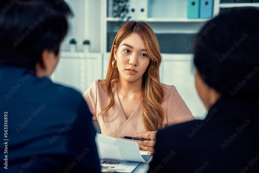 A young female asian candidate tries to impress her interviewer by being competent. International co