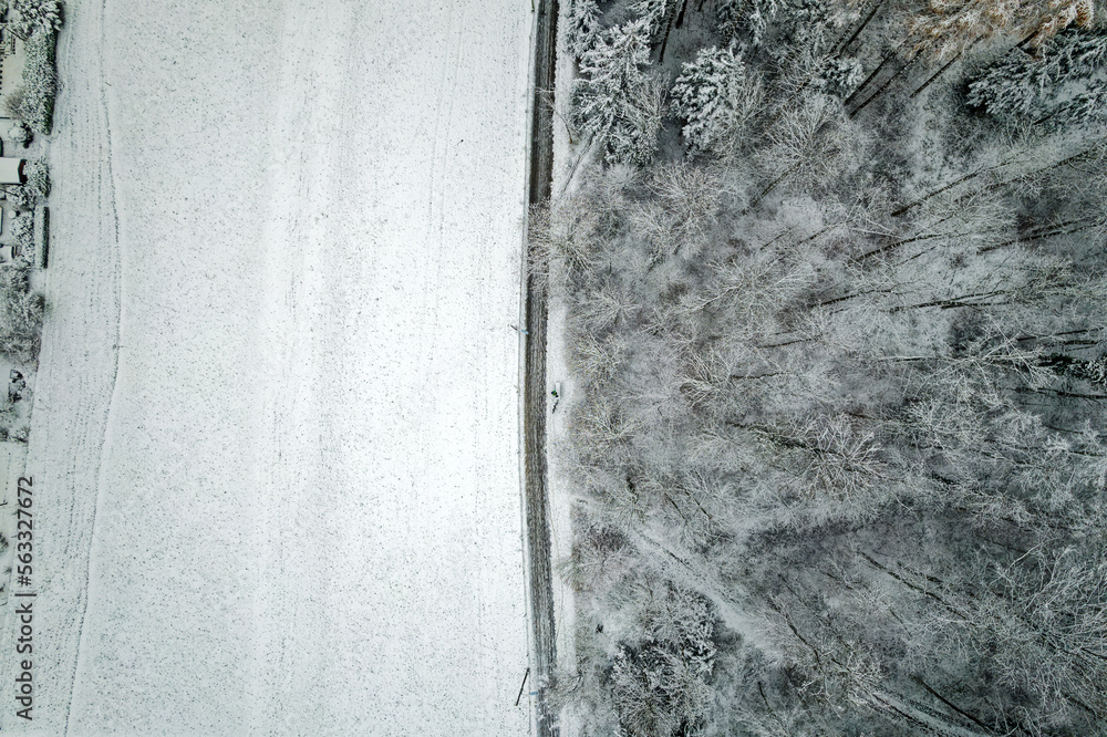 Top view of snow covered woodland with rural road at City of Zürich on a late autumn morning. Photo 