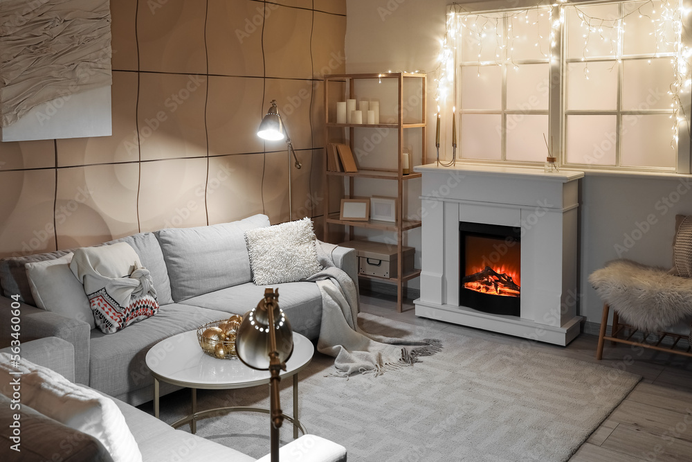 Interior of modern living room with electric fireplace, window and glowing lights