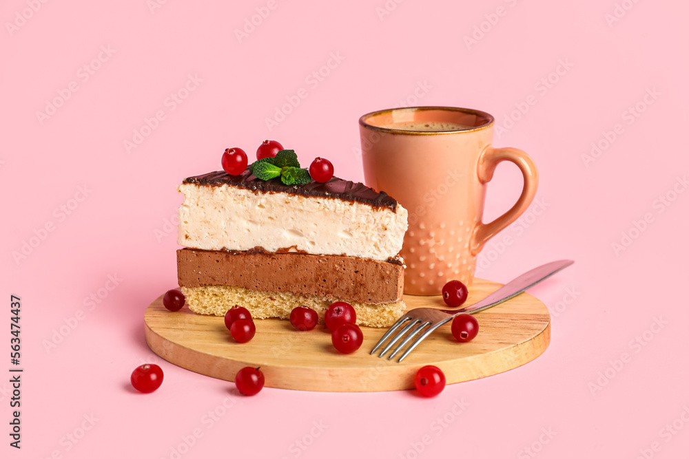 Tray with piece of birds milk cake, cranberries, mint leaves, fork and cup of drink on pink backgrou