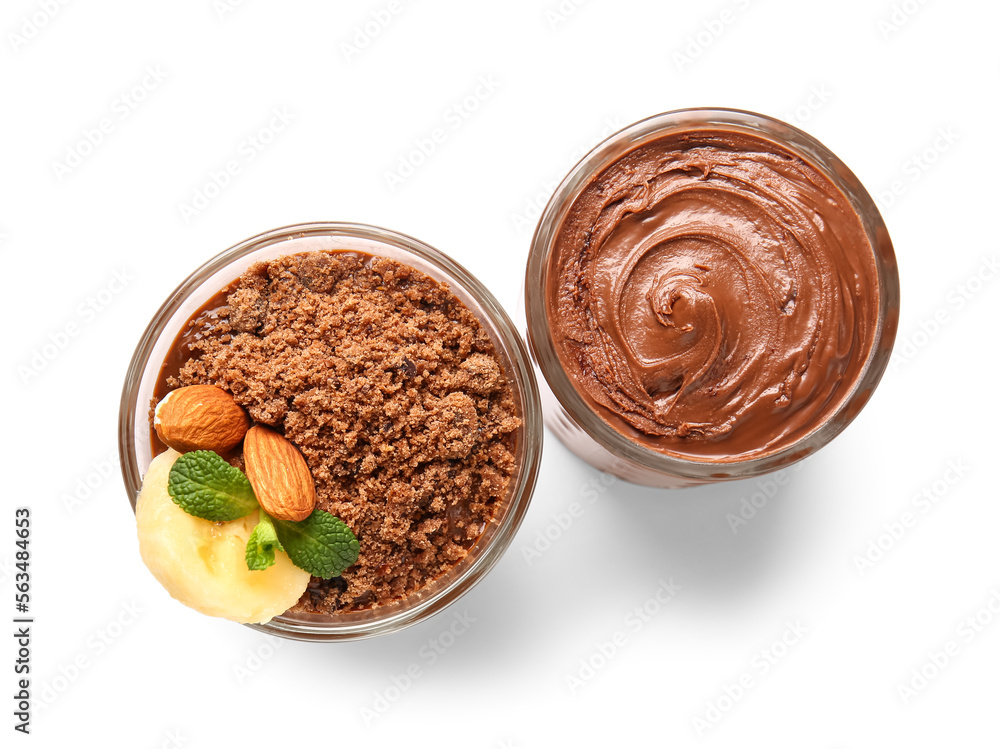 Glasses of chocolate pudding with almond, mint and banana slice isolated on white background