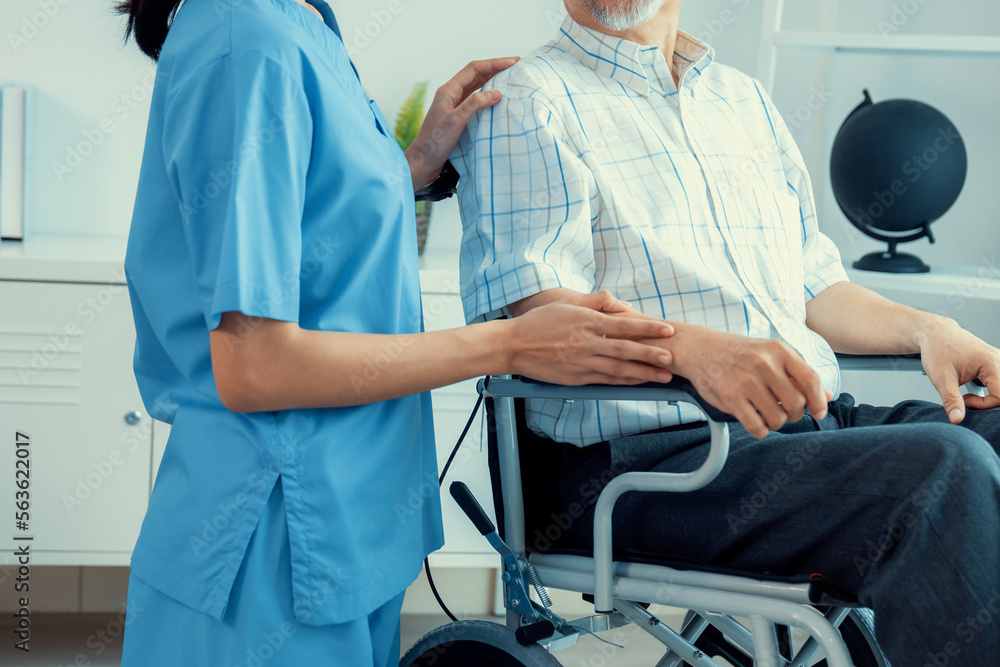 Happy positive asian nurse giving support and touching contented senior man with love. Nursing home 