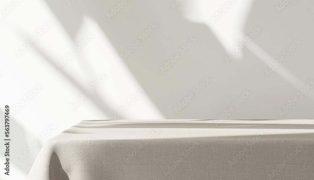 Table counter with beige tablecloth drape in sunlight, tropical leaf shadow on blank white wall in b