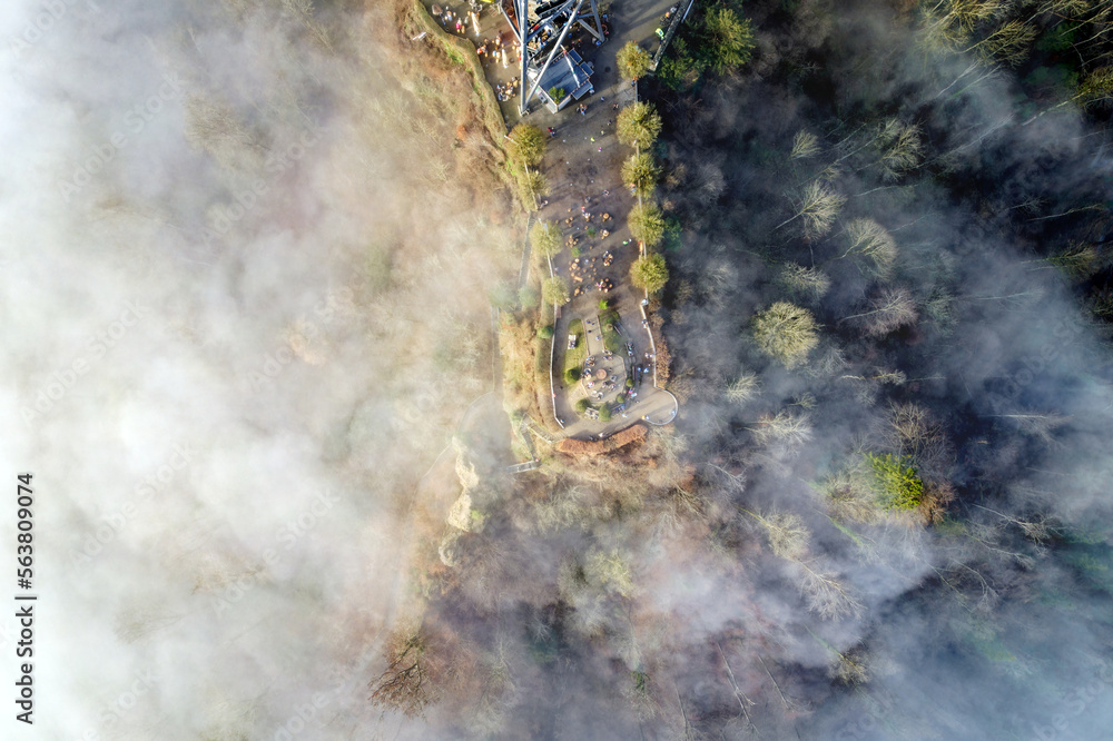 Top view from local mountain Uetliberg on a foggy winter day with lookout point and lookout tower fo