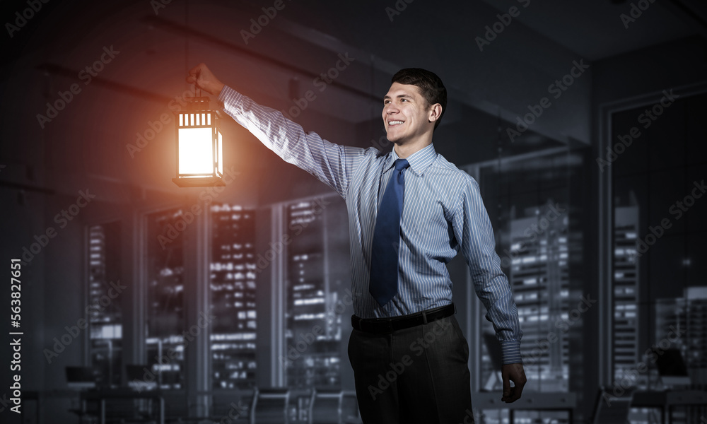 Happy businessman holding glowing lantern