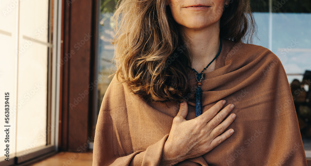 Mature woman wearing a crystal necklace at home