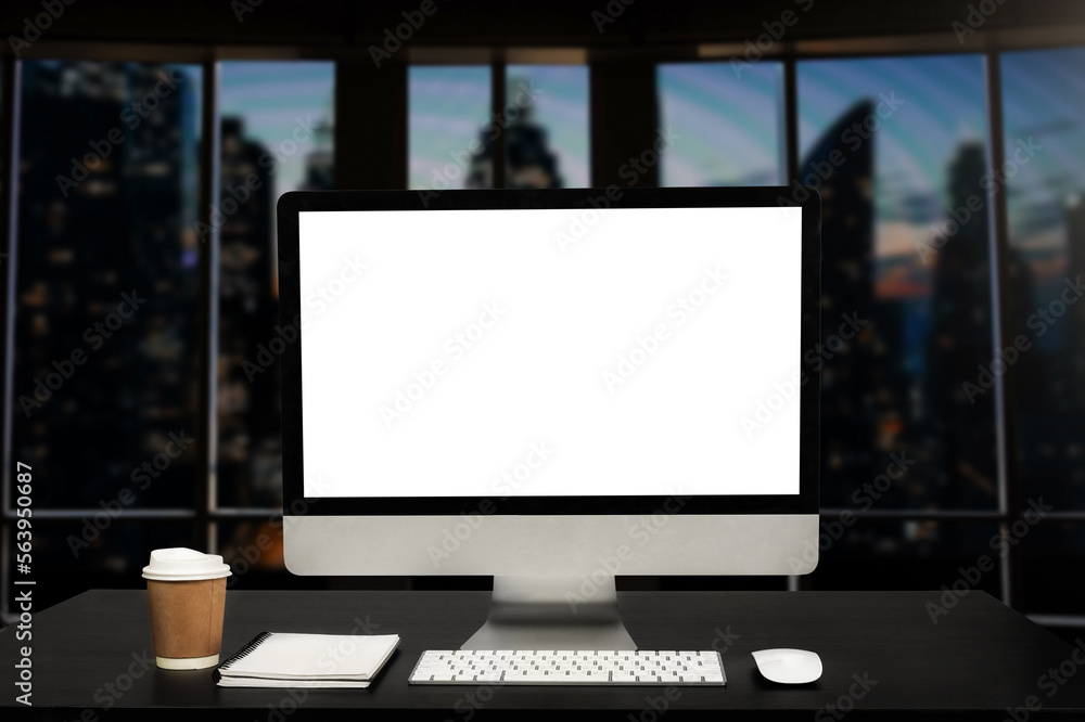 Workspace computer putting on wood working desk and surrounded by coffee cup, clipboard, potted plan