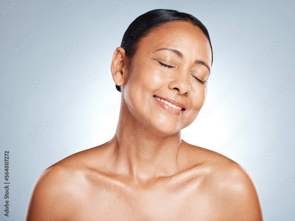 Skincare, glow and face of a senior woman with beauty isolated on a blue background in studio. Smile