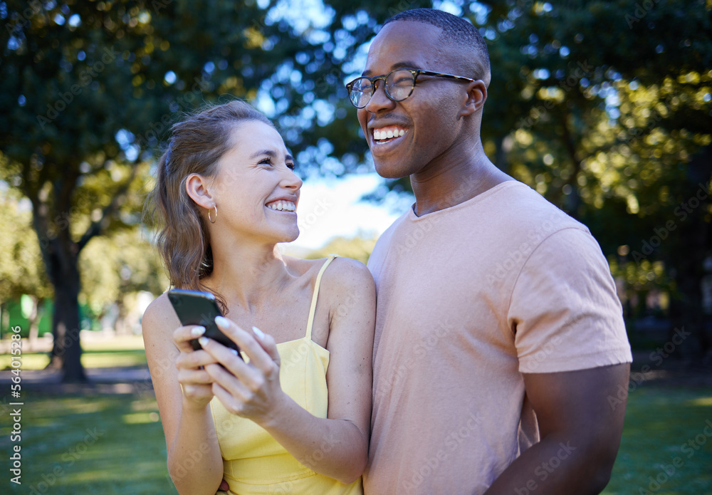 Comedy, laughing and interracial couple with a phone in nature, funny communication and smile at a m