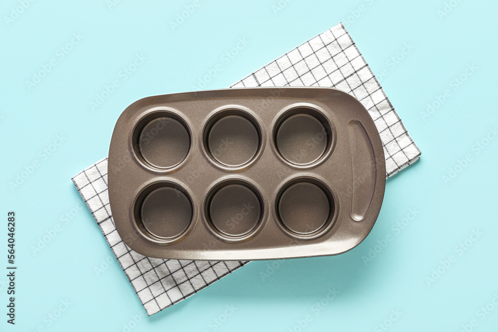 Muffin baking tray and napkin on blue background