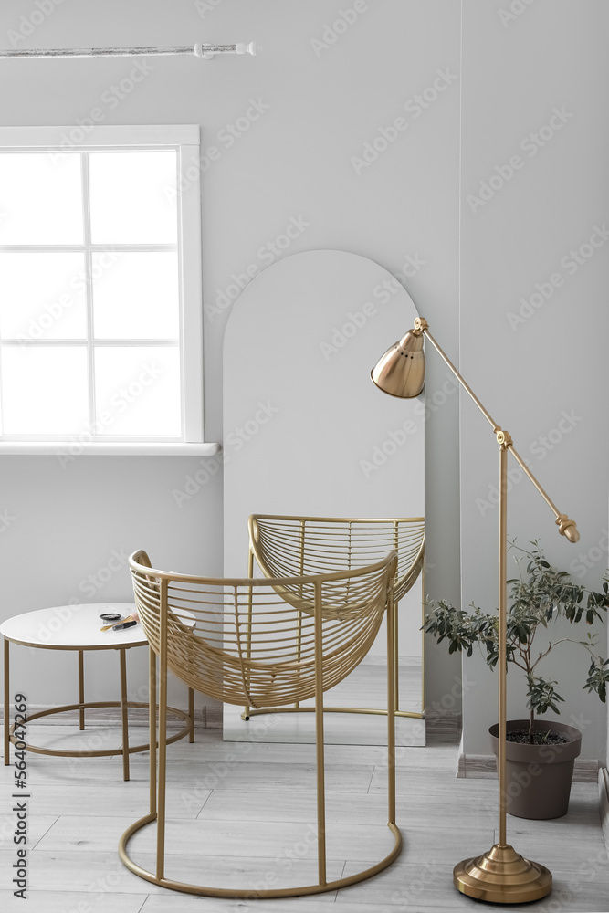 Interior of stylish dressing room with table, mirror and armchair