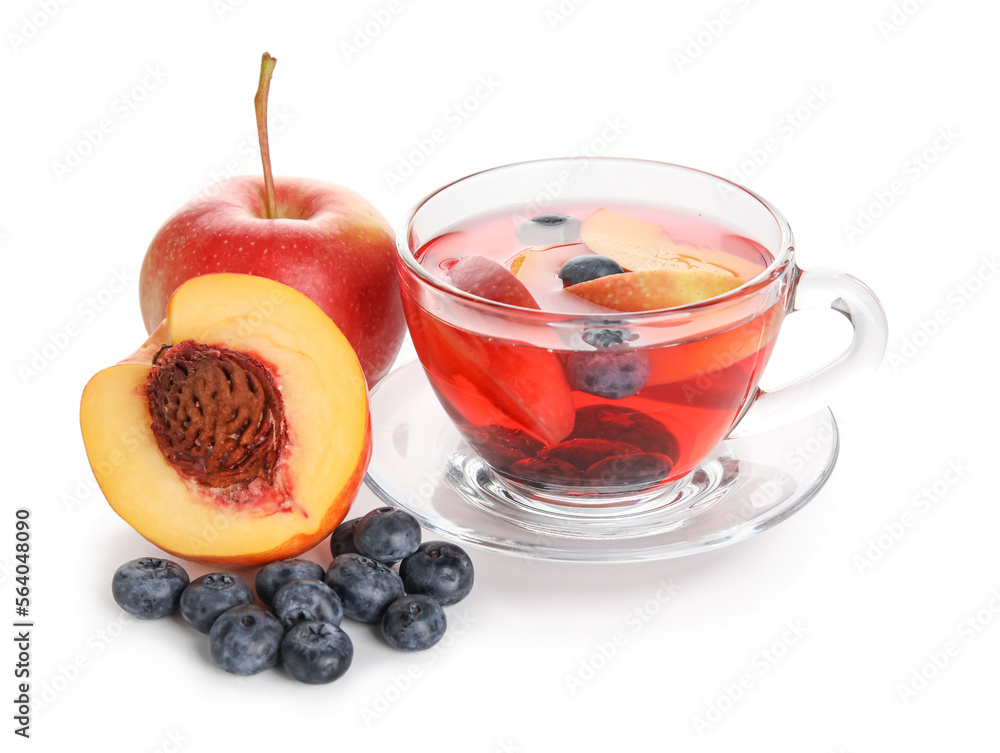 Glass cup of fruit tea with blueberries, apple and peach on white background