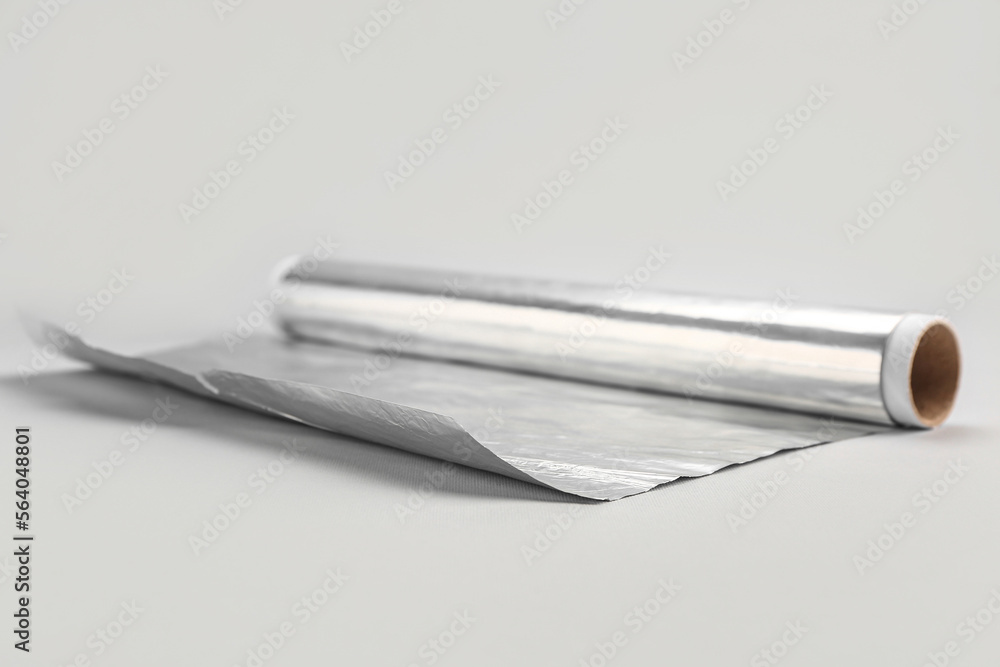 Roll of aluminium foil on grey background