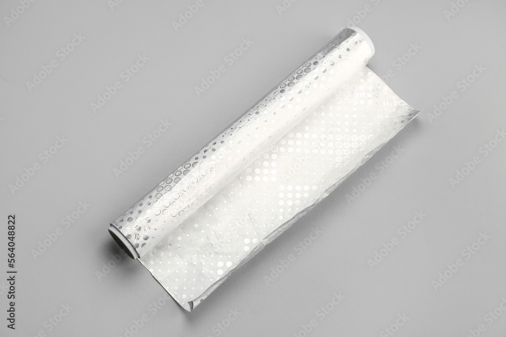 Roll of aluminium foil on grey background