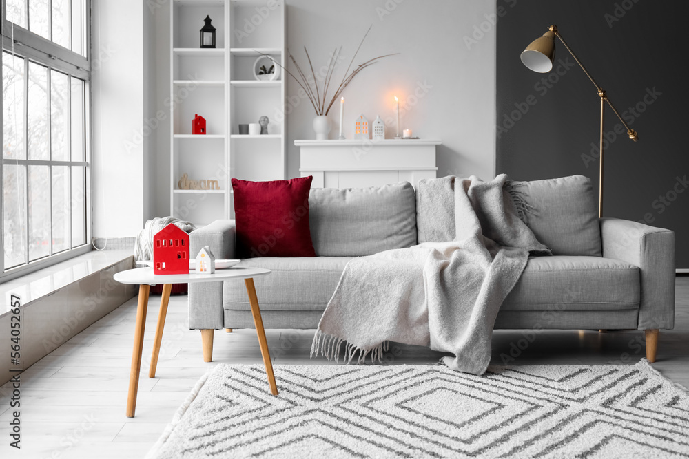 Interior of living room with house candle holders on table and sofa