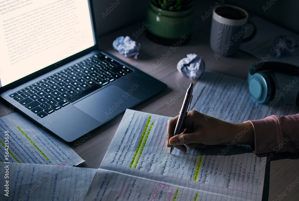 Student, hands and writing notes at night with laptop for research, education and internet project. 