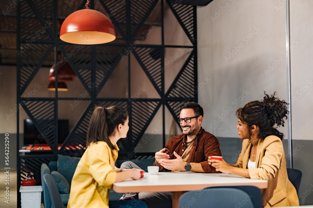 Smiling business people talking about new business projects, drinking coffee during the work break.