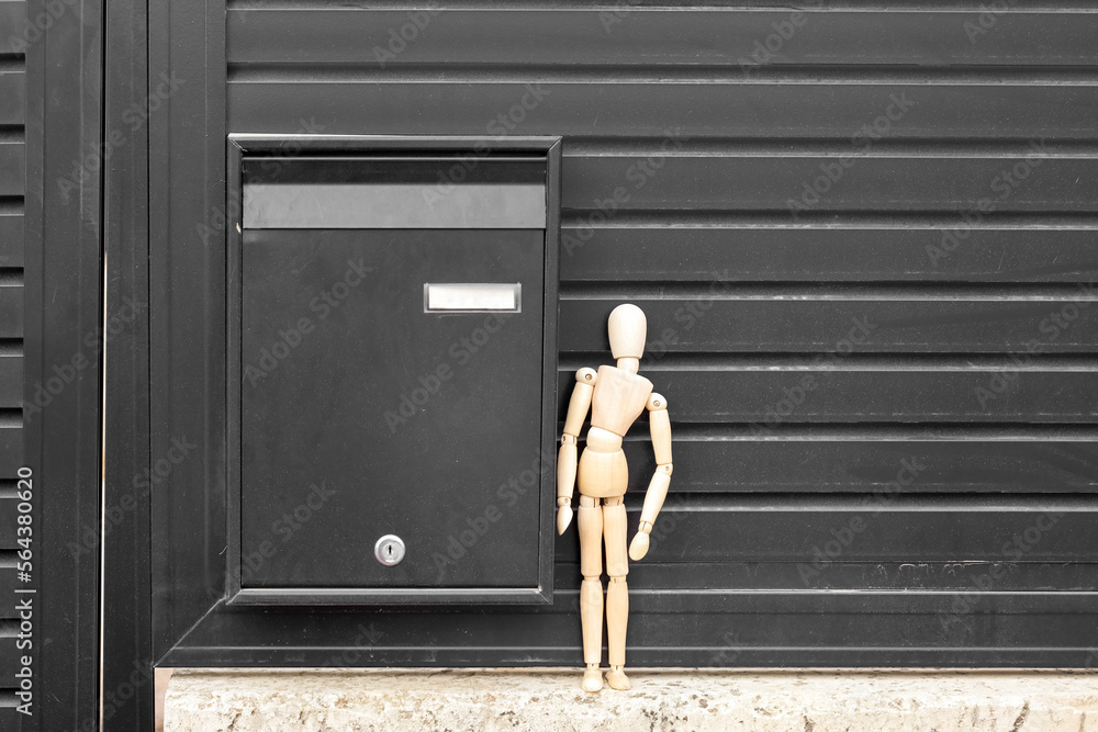 Fence with mailbox and wooden mannequin outdoors, closeup