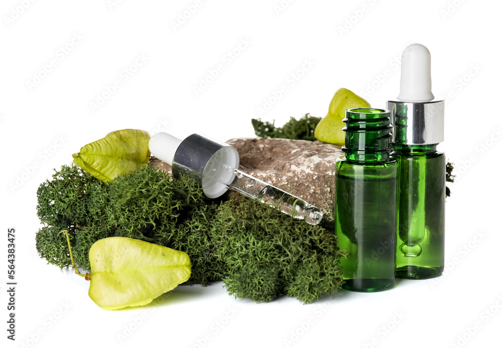 Cosmetic dropper bottles with green moss and rock on white background