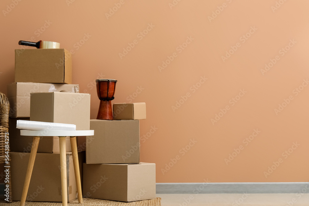 Moving cardboard boxes with table near color wall