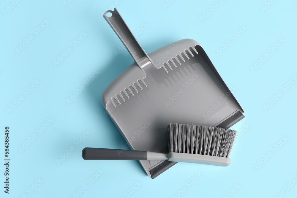 Dustpan and brush on color background