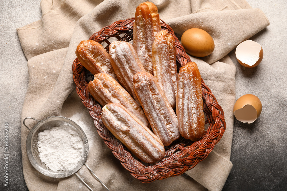 Wicker basket with sweet eclairs on black and white background