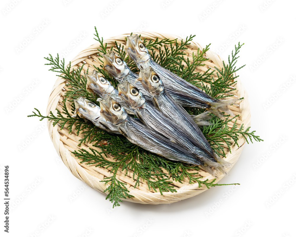 A colander placed on a white background with a serving platter of Japanese sardines.