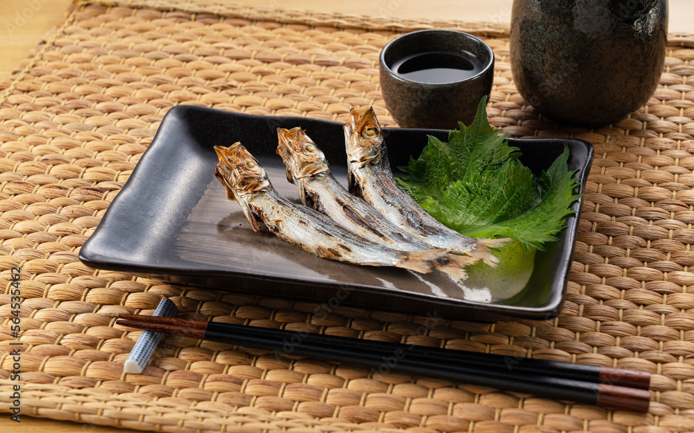 Grilled urume sardine placed on the table. A side dish of sake.