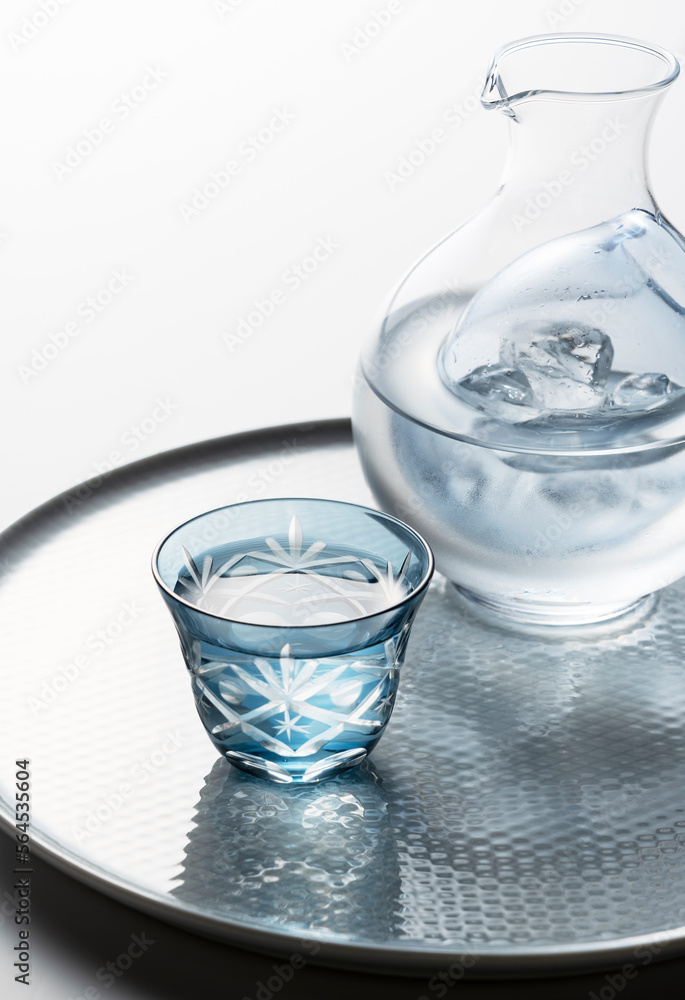 Sake poured into a faceted glass on a white background.