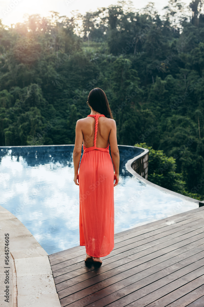 Woman standing by swimming pool at resort