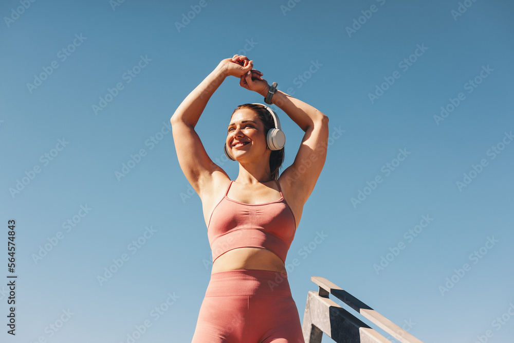 Woman in sportswear stretching her arms outdoors