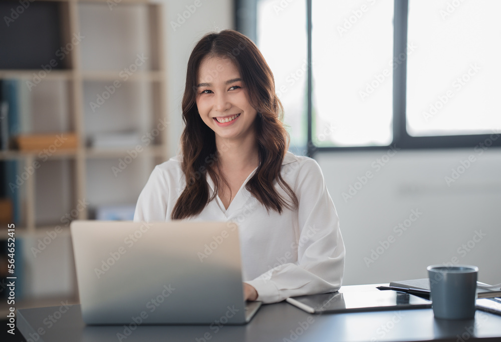 Young beautiful businesswoman working on her project in modern office room.