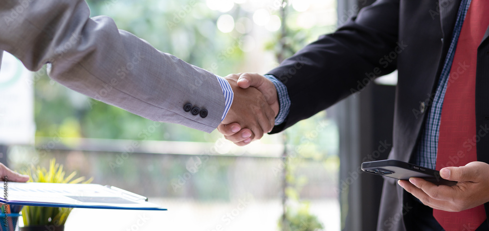 Business people shaking hands in a meeting to discuss planning a business project together.