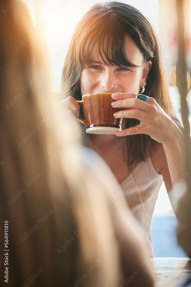 Woman, friends and drinking coffee for conversation, chatting about social life or gossip at an outd