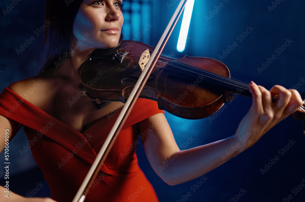 Closeup portrait of gorgeous elegant woman playing violin