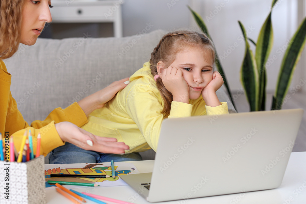 Upset little girl and her mother video chatting with psychologist on laptop at home