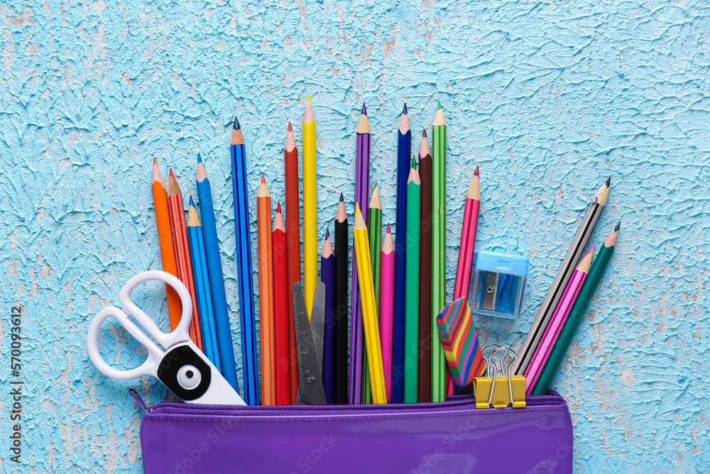 Case with pencils, scissors, eraser and sharpener on color background, closeup